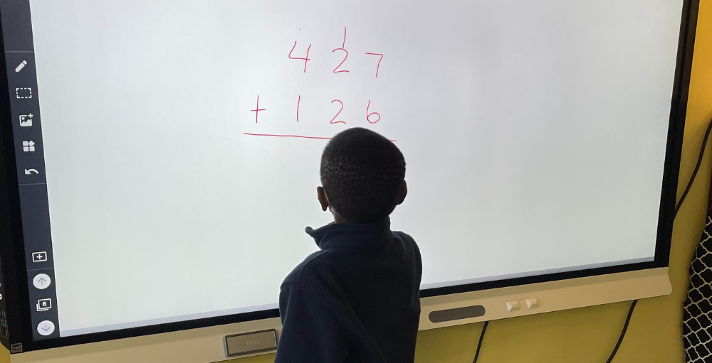 Syracuse Academy of Science elementary school students were eager to try out their new SMARTBoards and volunteered to solve math equations on the board. The markers were sanitized and changed between student’s use.
