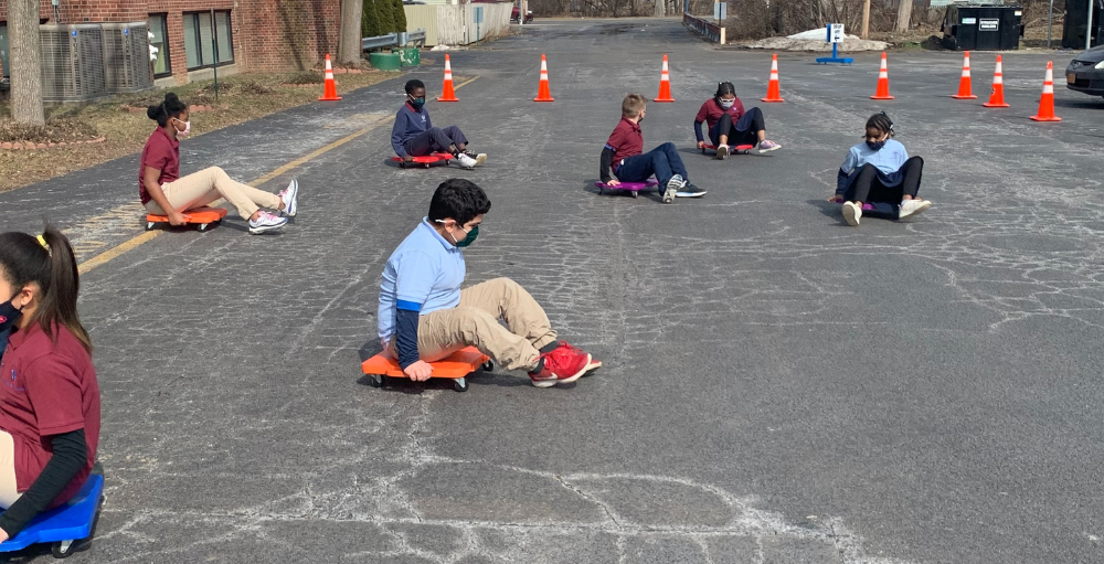 Syracuse Academy of Science elementary hybrid learning Atoms enjoy a socially distant outdoor recess on an unseasonably warm day, where they played with scooters.