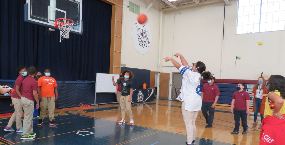 Syracuse Academy of Science middle school students compete in a free throw contest for their 'what's March without a little 'Madness'' celebration.