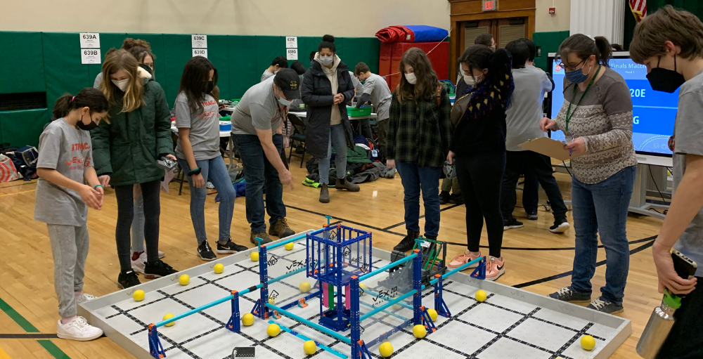 Syracuse Academy of Science middle school’s robotics team demonstrates their robot for a team of judges in the Vex Robotics Competition.
